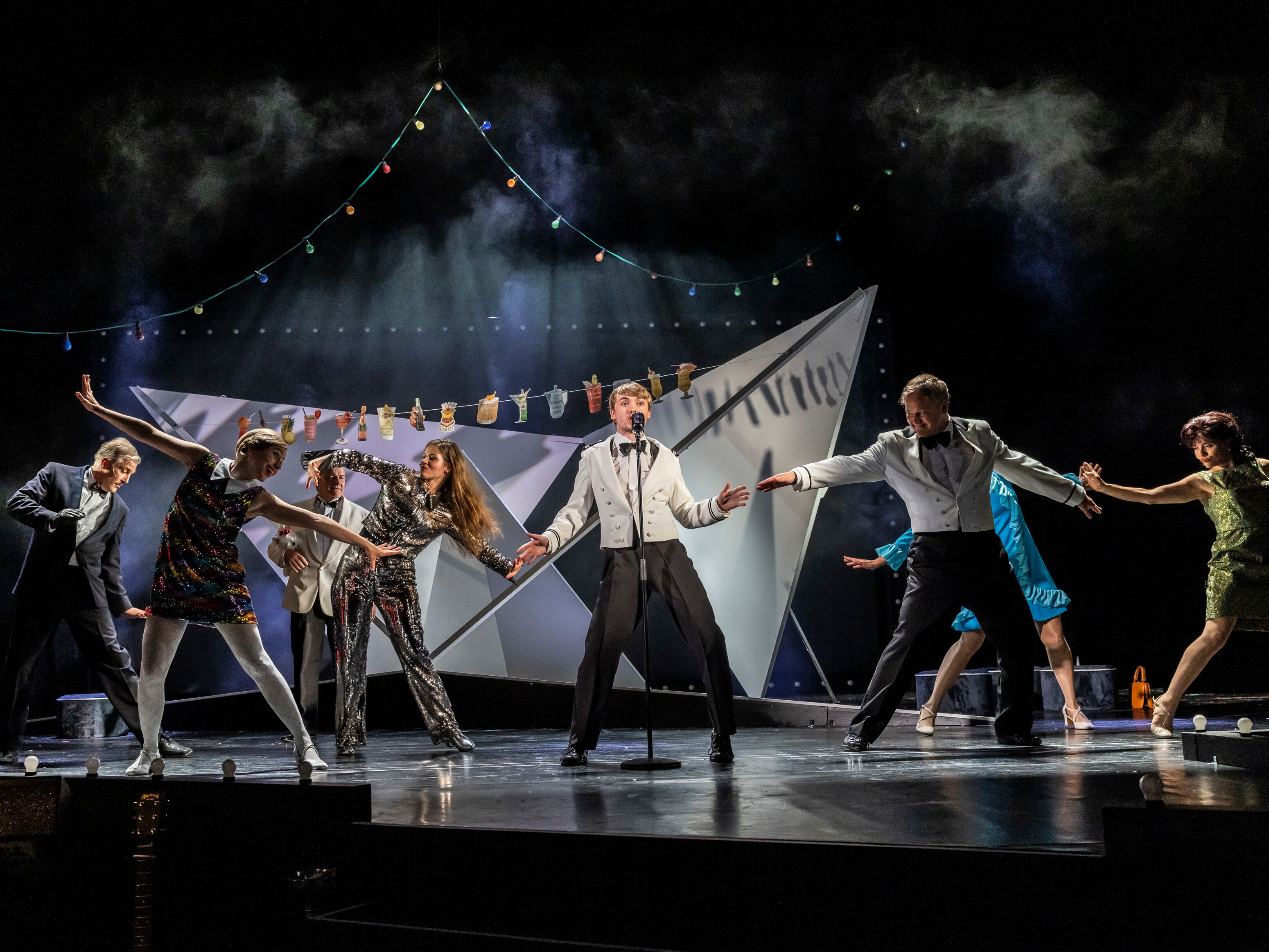 Ensemble von "Petticoat und Minirock" auf der Bühne im Theater Lüneburg, in bunten 60er-Jahre-Kostümen, beim Tanzen und Singen unter einer Wäscheleine. Foto: Jochen Quast.